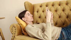 Close up view of a girl on the couch with smartphone