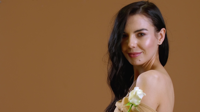 Beautiful young woman with white rose on color background | Shutterstock HD Video #1053995246