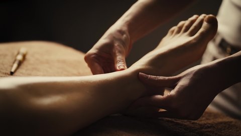 Professional foot massage. Authentic footage of luxury spa treatment. Charming light. Shallow depth of field. Stylized and colored.