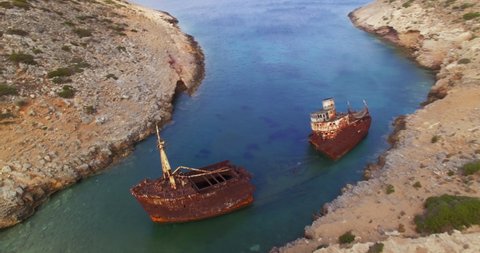Aerial footage of rusty shipwreck half submerged in a shallow cove. 2 clips included (colored in rec709, and raw LOG uncompressed) in true C4k lossless Prores.