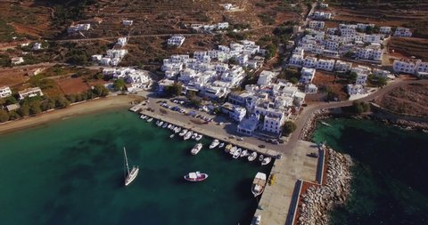 Aerial landscape of rustic Greek dock full of fisherman boats and a classic white and blue painted harbour town. 2 different clips included (aerial dock, aerial town) in true C4k lossless Prores.