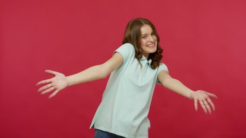 Cheerful lively energetic young woman in polo t-shirt going out on red background, pointing to sides, up and down, emotionally showing around place for advertising and thumbs up. studio shot isolated