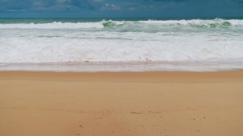Natural videos the waves in the sea moving towards the coast with cloud. Phuket Sea in the summer are high, intense and foamy white, perfect for playing surf. wide angle shot in 4K Resolution