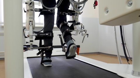 KHARKIV, UKRAINE - JULY 10, 2019: Female passes robotic gait therapy in rehabilitation medical center. Hospital for prosthetics of lost limbs after an accident
