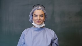 Female Doctor or Nurse Wearing Scrubs and Protective Mask and Goggles Banner. The doctor wears a mask. 4K slow motion video.