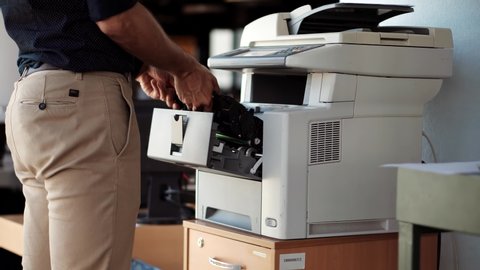 IT Support Copier Maintenance In Office Removing And Changing Toner Tube. Man From Helpdesk Replace Cartridge In Printer. Hand Swapping Cartridge On Multifunctional Printer. Employee Working In Office