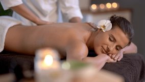 Woman enjoying body massage at spa club