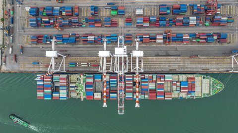 4K Timelapse Aerial view of industrial port with container loading by crane to container ship