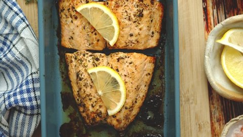 Close up shot of healthy grilled salmon served in heat proof ceramic dish. Placed on wooden board. Top view. Flat lay