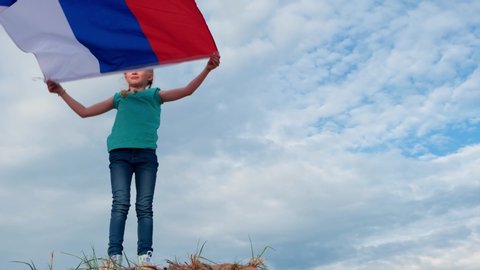 4k.Blonde girl waving national Russia flag outdoors over blue sky at summer - russian flag, country, patriotism, Russia day 12th june
