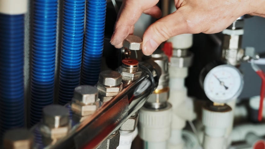 Professional plumber. Plumbing repair service. Repairman fixing a gas water heater with a screwdriver. Worker hands fixing heating system Royalty-Free Stock Footage #1054030343