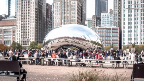 Chicago, IL - November 3rd, 2018: Millennium Park swarms with people on a sunny fall day as tourists and locals hang out at the plaza near the famous Cloud Gate sculpture by Anish Kapoor.