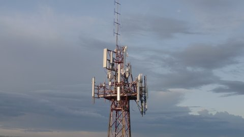Cellular and Internet tower with antennas and Dish Tv for transmitting 3G, 4G or 5G signals, aerial shot.