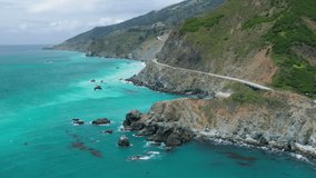Amazing aerial view of the Pacific coastline stunning nature. The most beautiful Californian 101 highway at the turquoise ocean water. 4K drone video of traffic at Big Sur park, USA