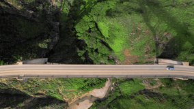 A unique perspective of the narrow bridge over the deep green canyon. Cinematic 4K aerial footage of tourists traveling to the world-famous majestic architecture landmark in California, USA.