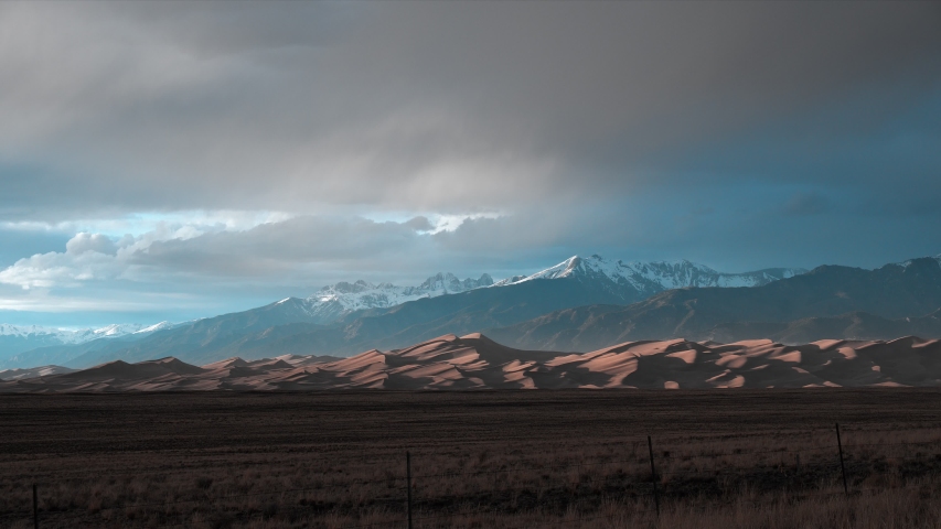 Colorful sunrise over mystic Great Sand Dunes National Park Preserve Low View. Scenic Dawn Sunlight Overview. Sunset Wild Nature Landscape. Dramatic Sky, Moving Clouds Float. Time Lapse Footage UHD