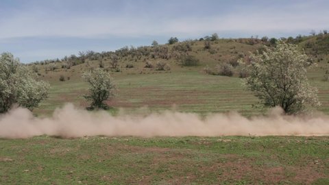 Rally car, drone view, off-road racing with dust, moving fast