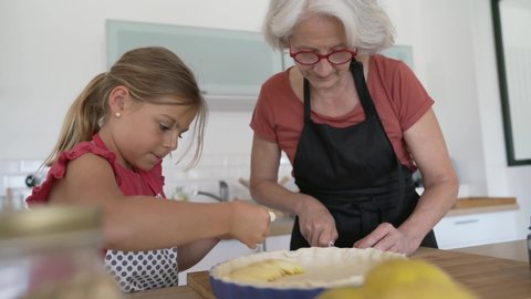 Grandmother with grandkid making apple pie 