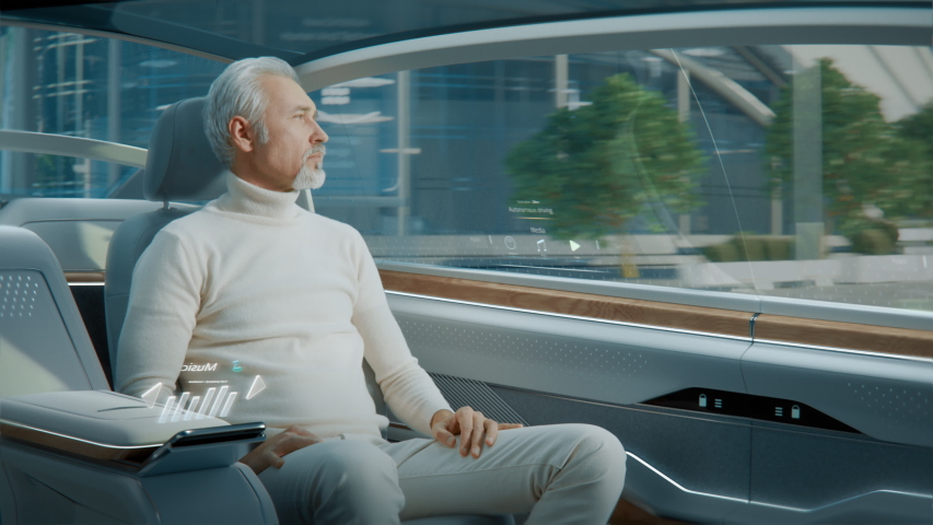 Futuristic Concept: Handsome Stylish Man Using Futuristic Augmented Reality Interface for Reading News and Checking Social Activity while Sitting on a Backseat of Autonomous  Self-Driving Car.  Royalty-Free Stock Footage #1054062317