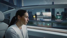 Futuristic Concept: Zoom Out View of an Attractive Female Reading the News on a Futuristic Augmented Reality Interface while Talking to Another Passenger. Riding in an Autonomous Self-Driving Car - Powered by Shutterstock - Get 15% off with code: PIKWIZARD15