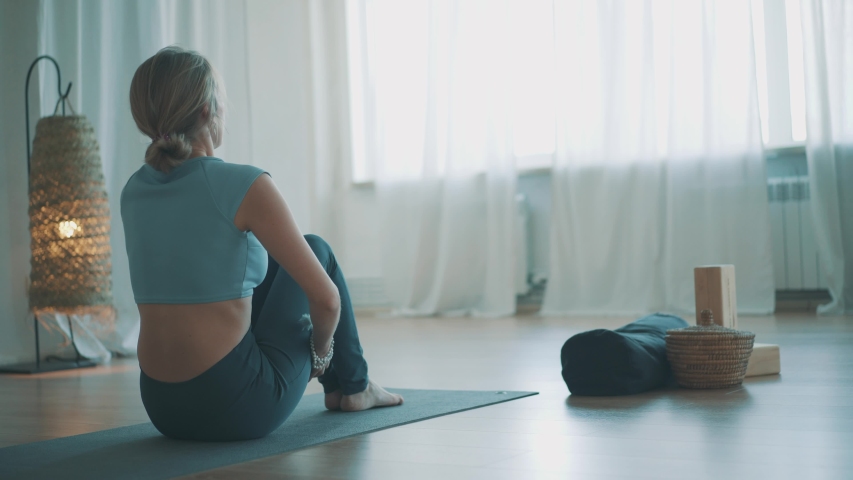 Blond woman yoga teacher in blue sports wear practicing yoga at home in cozy interior and big windows.
Lady doing navasana pose for slim belly and power state. internet detox and time for self care
 Royalty-Free Stock Footage #1054064318