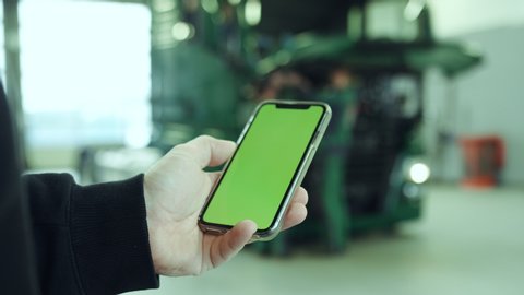 Person using a phone with green screen in front of a truck