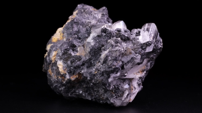 Shiny rock with cerussite crystals slowly rotating over a black background. Also known as lead carbonate.