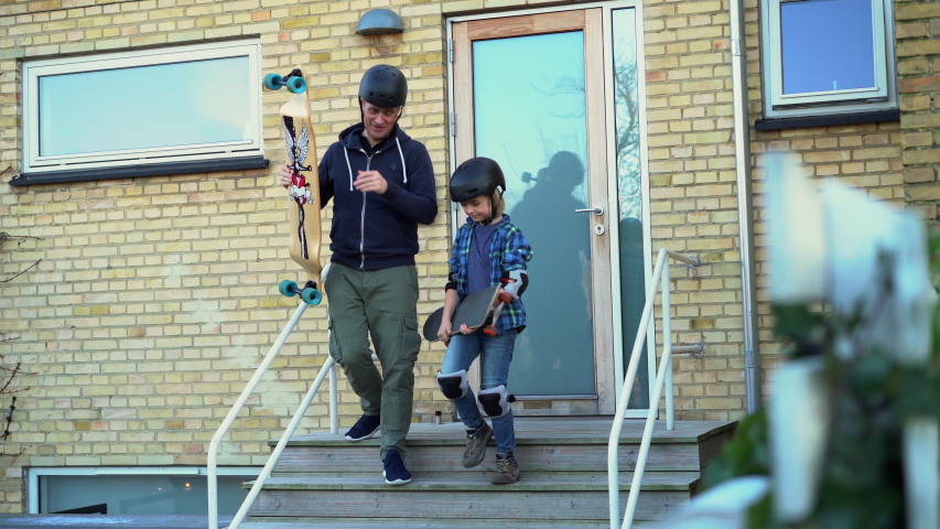 father and son skateboarding on a suburban street