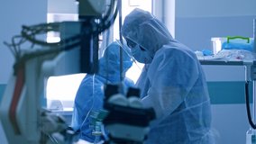 Life support equipment in clinic during pandemic. Coronavirus medical workers in protective uniform and mask in the hospital. Artificial lungs ventilation. Covid-19. - Powered by Shutterstock - Get 15% off with code: PIKWIZARD15