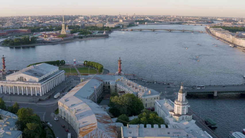 Aerial video of Old Stock Exchange building and Rostral columns, center of Saint Petersburg at sunset, Russia, boats on the Neva river, Trinity bridge, Peter and Paul Fortress