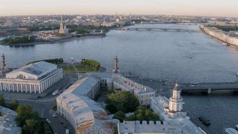 Aerial video of Old Stock Exchange building and Rostral columns, center of Saint Petersburg at sunset, Russia, boats on the Neva river, Trinity bridge, Peter and Paul Fortress