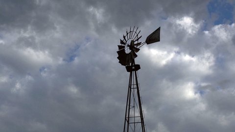 Farm Windmill silhouetted against clouds