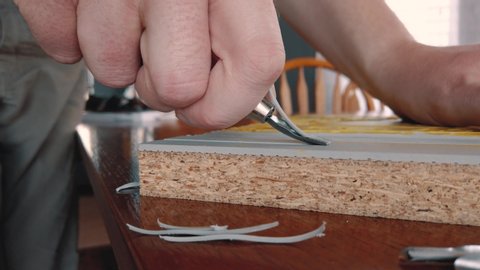 Camera closely follows a linoleum carving tool as it smoothly removes a long piece of linoleum off of a lino block giving a sense of creation and comfort