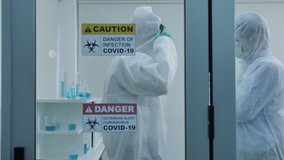Two asian scientist is wearing Personal Protective Equipment (PPE) in laboratory. Protection coronavirus or covid19 and Medical experiment concept. Slow motion Dolly slider shot - Powered by Shutterstock - Get 15% off with code: PIKWIZARD15