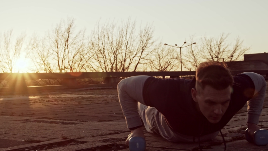 Young and fit man having evening workout outdoor. Urban sunset background. Fitness and sport.