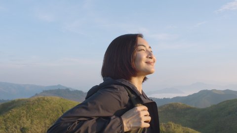 Young Asian Woman Smiling And Enjoying The Sunrise On Top Of A Mountain
