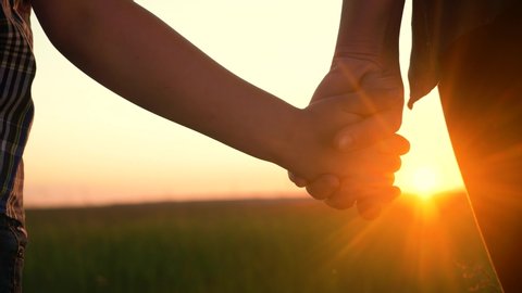 happy family mom and son hold hands close-up teamwork. mother and boy kid together hands at sunset. parent girl and child happy childhood. lifestyle happy family mother day concept