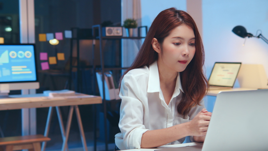 Young Asian business woman on video conference call, using laptop computer work late night. Remote meeting, work at home, internet technology, Covid-19 quarantine lockdown new normal lifestyle concept | Shutterstock HD Video #1054104248