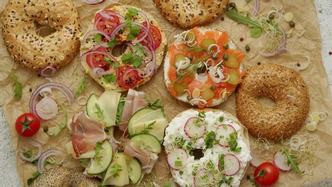 Tasty colorful various bagels with healthy ingredients served on brown baking paper. Delicious snack concept. Top view.