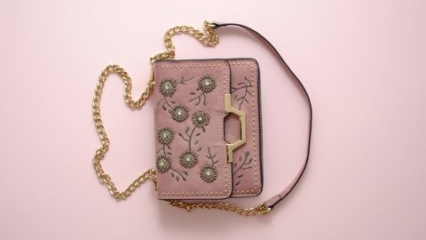 Festive evening women bag isolated on pink background. Luxury female accessories and party concept. Top view, flat lay.