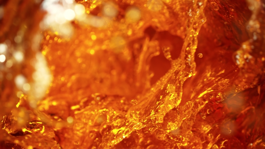 Super Slow Motion Shot of Falling Ice Cubes into Golden Liquid Vortex at 1000 fps.