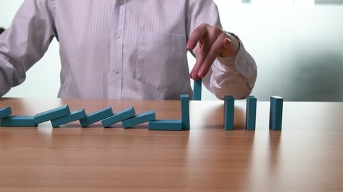 Slow motion video of businessman hand pick up one domino