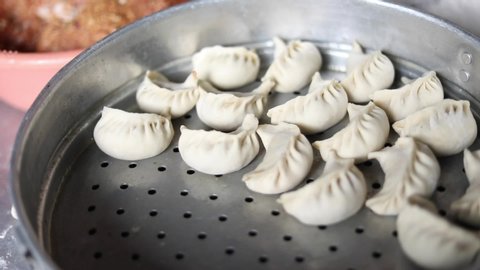 Freshly stuffed chicken momos in a steamer ready to be cooked. 
