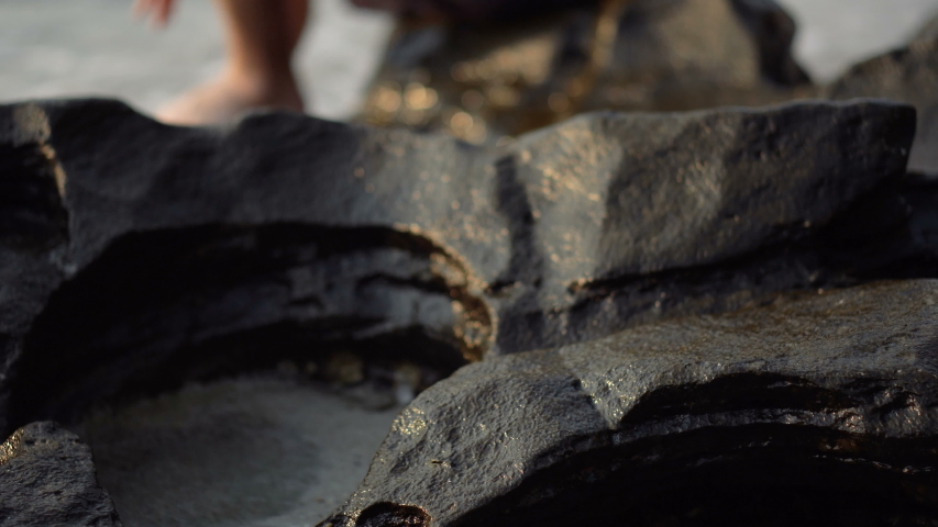 Happy Tourist Man Sitting on Beach of Tropical Island Smiling Into Camera With Ocean and Shore in Background