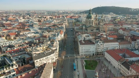 Budapest, Hungary - 4K aerial view of Bajcsy-Zsilinszky street on a sunny afternoon flying backwards from St. Stephen's Basilica with blue bus and low traffic bellow