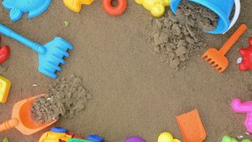 Sand is falling into a children's sandbox. Summer background with toys. 4K video