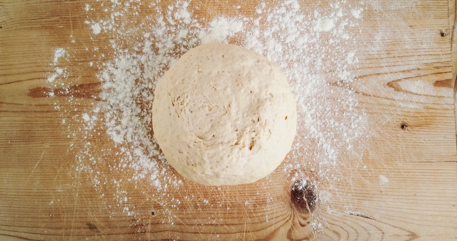 Pizza dough while rising on a wooden cutting board Royalty-Free Stock Footage #1054121486