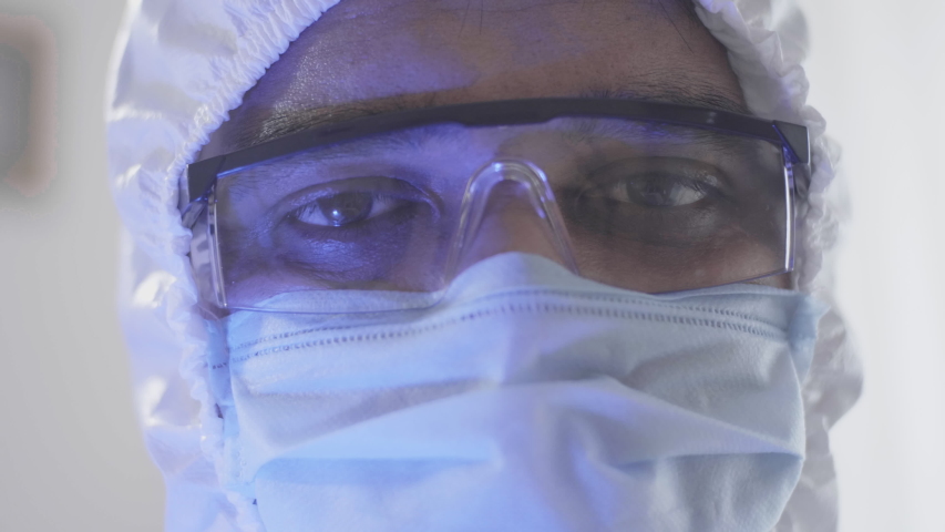 Close up shot of the tired and sleepy eyes of a male doctor or healthcare worker wearing personal protective kit while working in the hospital amid Coronavirus or COVID 19 epidemic or pandemic