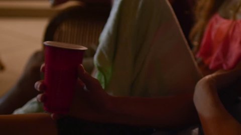 Closeup Of Teen Holding A Red Cup At A Summer Pool Party, He Takes A Sip, Girl Flirts With Him (4K) 