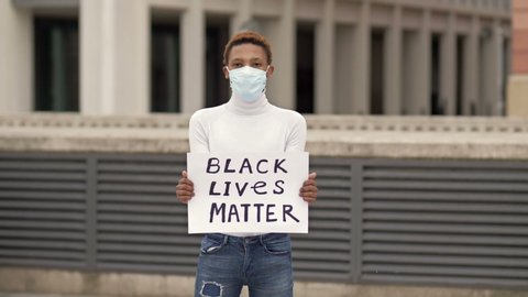 Poster BLACK LIVES MATTER in the hands of a black guy. Stop Racism concept.